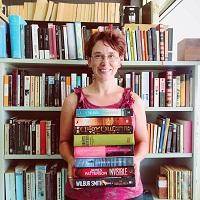 Image of owner standing in front of books