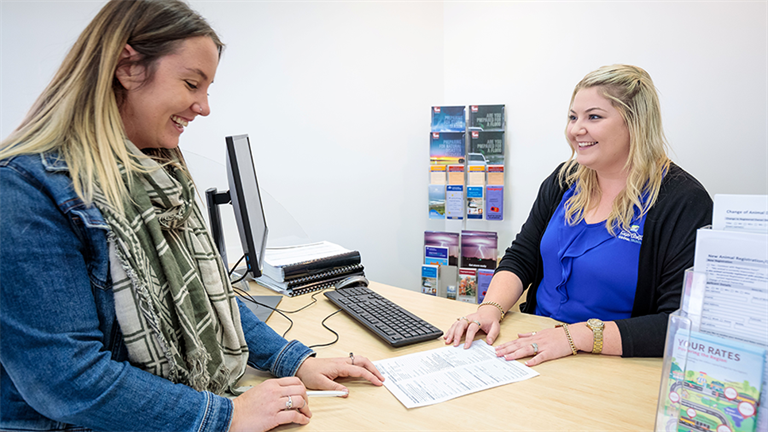 Customer being served at Customer Service desj