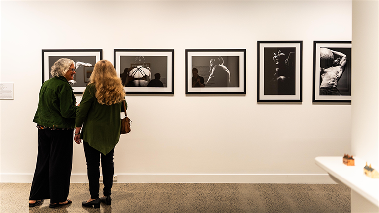 Two people admiring art at the Hervey Bay Regional Gallery