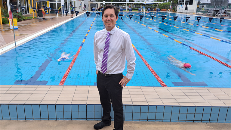 Mayor, George Seymour, standing in front of a swimming pool at the Hervey Bay Aquatic Centre. 