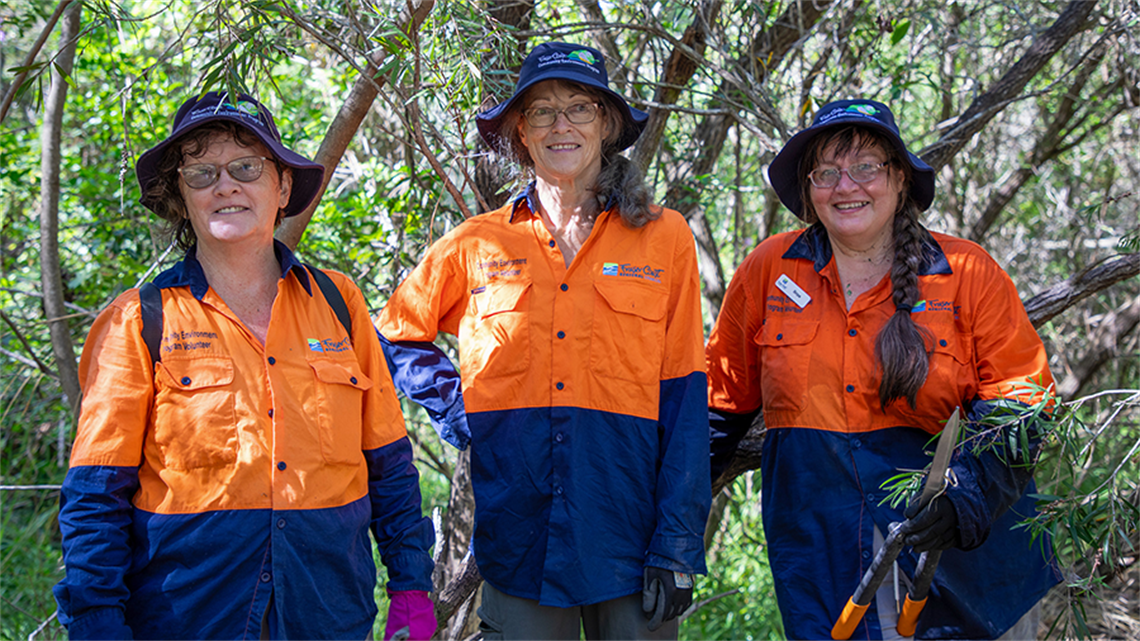 Group of Community Environment Program Bushcare Volunteers in high vis uniforms