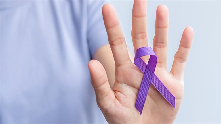 Person holding Domestic and Family Violence Ribbon in their hand