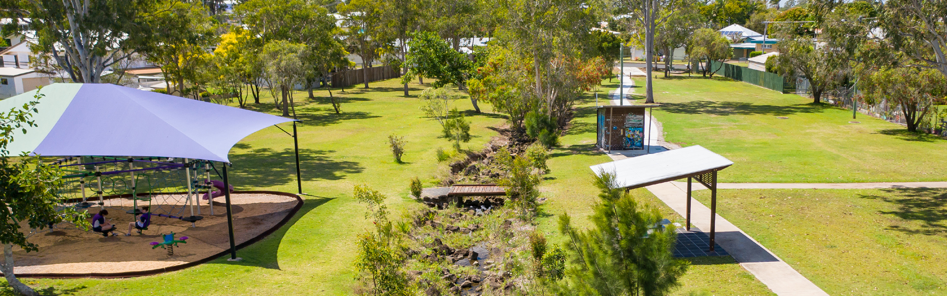 Aerial view of park with playgrounds, walking paths and shelters