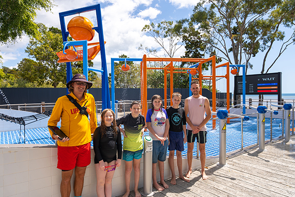 Cr Daniel Sanderson with a lifeguard and WetSide visitors on opening day